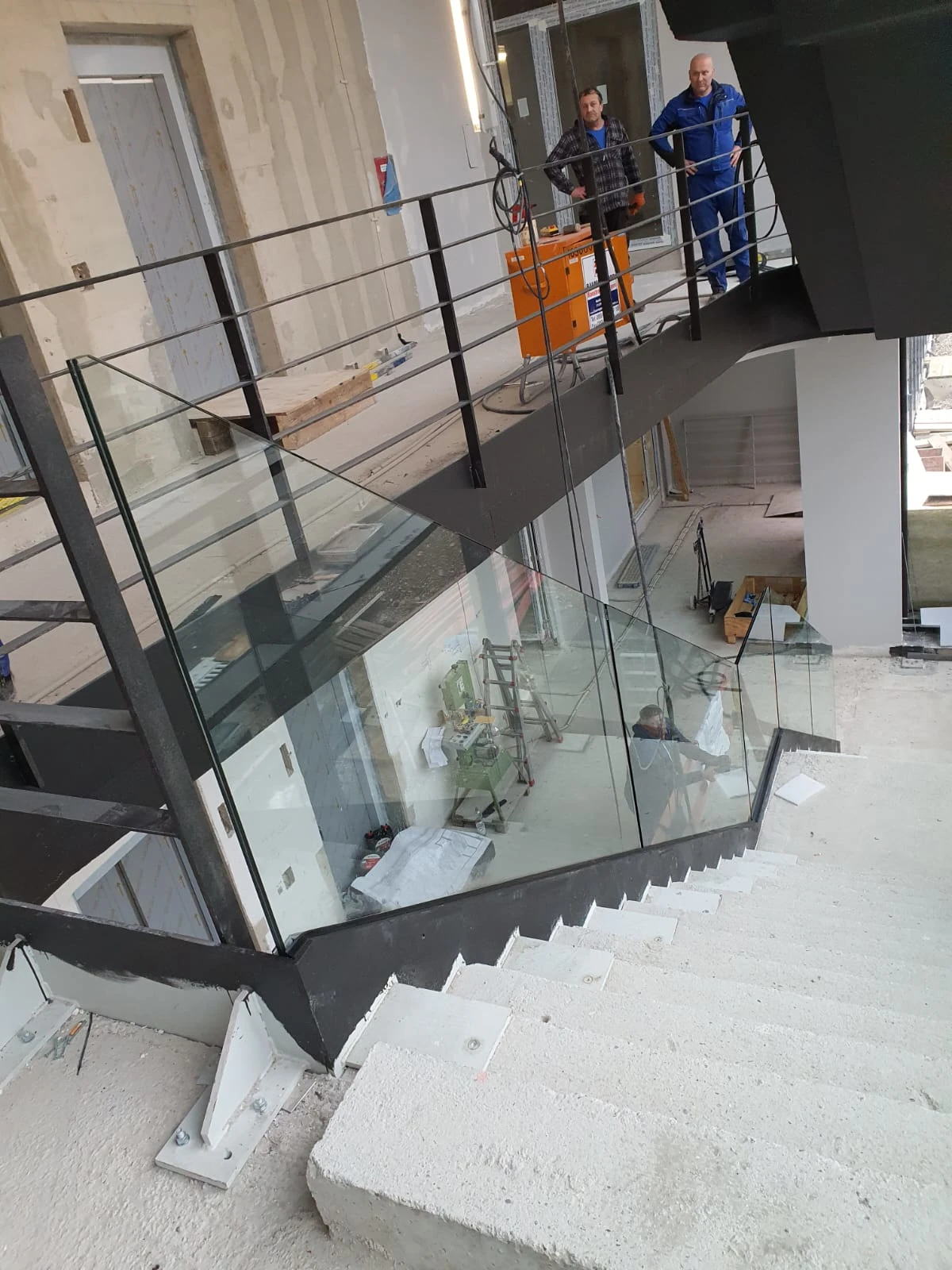 Metalltreppe mit Glasgeländer und Handlauf