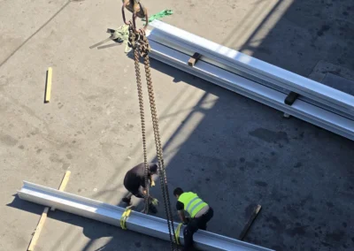 Mitarbeiter beim Anschlagen von Stahlträgern für einen Kranhub