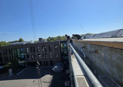 Stahlträger werden mit einem Mobilkran auf ein Dach gehoben
